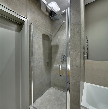 shower door - Contemporary bathroom with long tiles on the walls and floor. There is a shower cabin with a glass door, white bath, door, chrome towel holder, glowing lamps. Vertical. Stock Photo - Budget Royalty-Free & Subscription, Code: 400-08815581