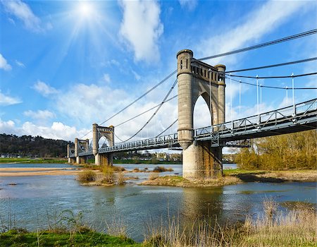 simsearch:400-08817566,k - Sunshine above spension Bridge spanning the Loire in Langeais, France. Built between 1846 and 1849. Architect Phidias Vestier. Photographie de stock - Aubaine LD & Abonnement, Code: 400-08817566
