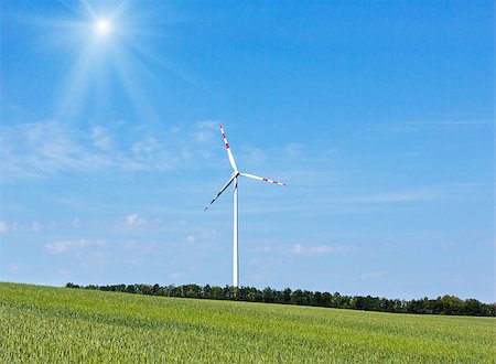 simsearch:400-08817566,k - Wind turbine on blue sunshiny sky background Photographie de stock - Aubaine LD & Abonnement, Code: 400-08817563