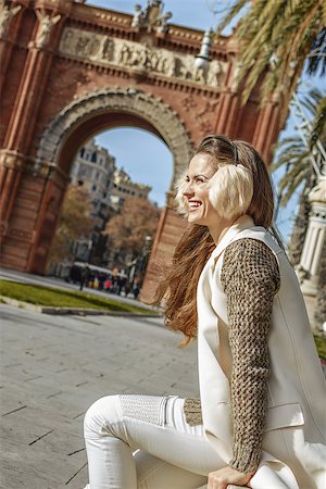 simsearch:400-08415527,k - in Barcelona for a perfect winter. happy elegant fashion-monger in earmuffs near Arc de Triomf in Barcelona, Spain sitting on a parapet Stock Photo - Budget Royalty-Free & Subscription, Code: 400-08817882