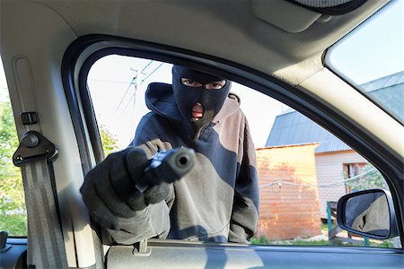 simsearch:400-08551381,k - An armed man in the mask threatening pistol to the driver of the car Fotografie stock - Microstock e Abbonamento, Codice: 400-08818496