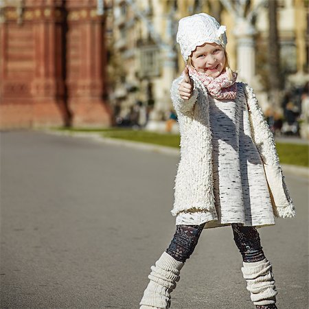 simsearch:400-08415527,k - in Barcelona for a perfect winter. Portrait of happy trendy girl in Barcelona, Spain showing thumbs up Stock Photo - Budget Royalty-Free & Subscription, Code: 400-08819159