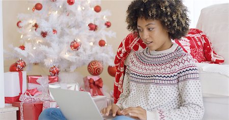 Excited young woman making a surprise find on the internet as she surfs the web at Christmas while relaxing in front of the tree Photographie de stock - Aubaine LD & Abonnement, Code: 400-08810054