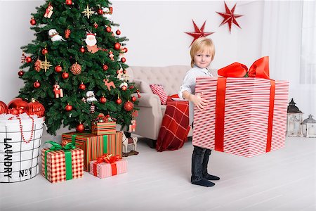 A boy with a big Christmas present near Christmas tree Stock Photo - Budget Royalty-Free & Subscription, Code: 400-08811203