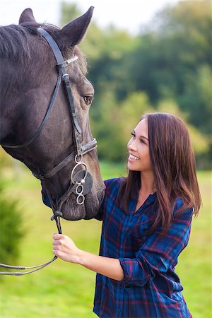 simsearch:400-08299085,k - Beautiful happy smiling Asian Eurasian young woman or girl wearing plaid checked shirt with her her horse in sunshine Stock Photo - Budget Royalty-Free & Subscription, Code: 400-08811938