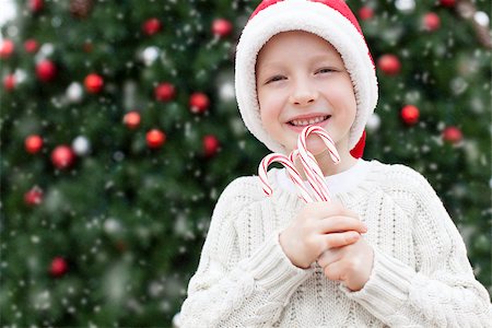snow cosy - little boy in santa's hat holding candy canes enjoying snowy christmas time Stock Photo - Budget Royalty-Free & Subscription, Code: 400-08811960