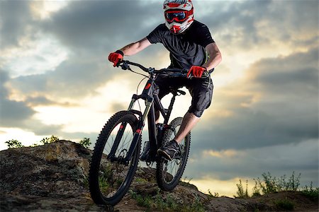 simsearch:400-09084281,k - Professional Cyclist Riding the Bike Down Rocky Hill at Sunset. Extreme Sport Concept. Fotografie stock - Microstock e Abbonamento, Codice: 400-08812566