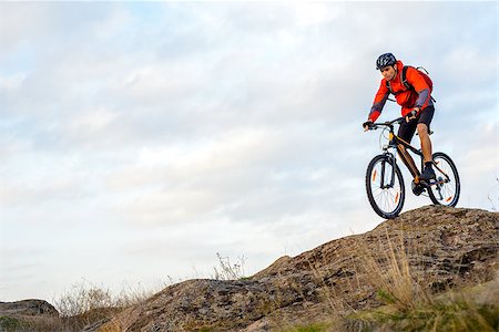 simsearch:400-08298519,k - Cyclist in Red Jacket Riding the Bike Down Rocky Hill. Extreme Sport Concept. Space for Text. Photographie de stock - Aubaine LD & Abonnement, Code: 400-08812560