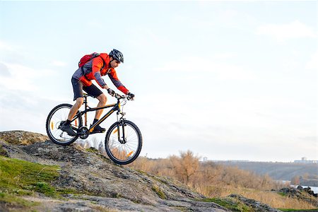 simsearch:400-08298519,k - Cyclist in Red Jacket Riding the Bike Down Rocky Hill. Extreme Sport Concept. Space for Text. Photographie de stock - Aubaine LD & Abonnement, Code: 400-08812561