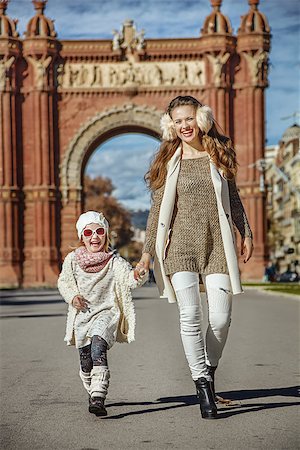 simsearch:400-08864986,k - in Barcelona for a perfect winter. Full length portrait of smiling trendy mother and daughter near Arc de Triomf in Barcelona, Spain walking Stock Photo - Budget Royalty-Free & Subscription, Code: 400-08813561