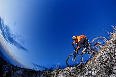 simsearch:400-09141350,k - Mountain biker in action across rocks against blue sky concept for healthy lifestyle, exercise and extreme sports Photographie de stock - Aubaine LD & Abonnement, Code: 400-08835255