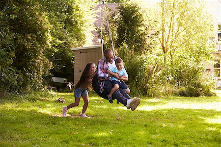 Daughter Pushing Father And Son On Tire Swing In Garden Stock Photo - Budget Royalty-Free & Subscription, Code: 400-08837784