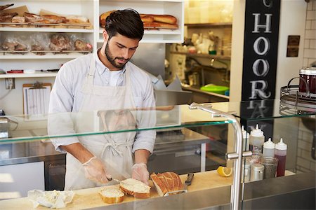 simsearch:400-08838017,k - Man preparing food behind the counter at a sandwich bar Photographie de stock - Aubaine LD & Abonnement, Code: 400-08837964