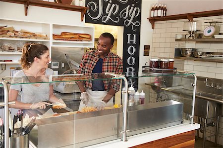 simsearch:400-08838017,k - Mixed race couple working behind counter at a sandwich bar Photographie de stock - Aubaine LD & Abonnement, Code: 400-08837975