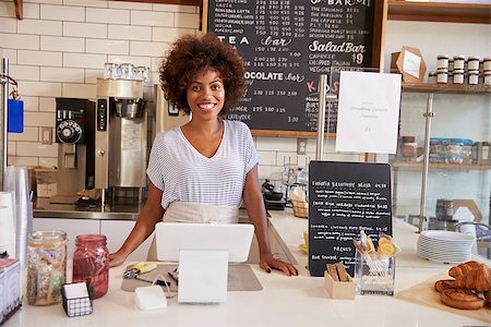 simsearch:400-08838017,k - Smiling waitress behind counter at a coffee shop, close up Photographie de stock - Aubaine LD & Abonnement, Code: 400-08837995