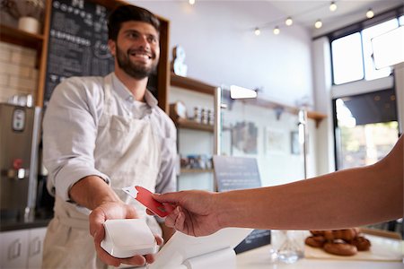 employee hold a sign - Barista takes credit card payment at a coffee shop, close up Stock Photo - Budget Royalty-Free & Subscription, Code: 400-08838016