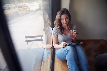 deli window - Young woman sits beside window in cafe using tablet computer Stock Photo - Budget Royalty-Free & Subscription, Code: 400-08838070