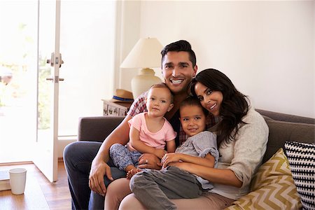 simsearch:400-09122233,k - Portrait Of Happy Family Sitting On Sofa In at Home Stock Photo - Budget Royalty-Free & Subscription, Code: 400-08838181
