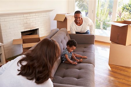 Parents Carry Son On Sofa Into New Home On Moving Day Stock Photo - Budget Royalty-Free & Subscription, Code: 400-08838277