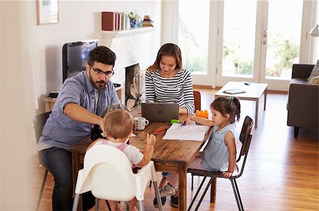 Mother Uses Laptop Whilst Father Plays With Children At Home Stock Photo - Budget Royalty-Free & Subscription, Code: 400-08838335