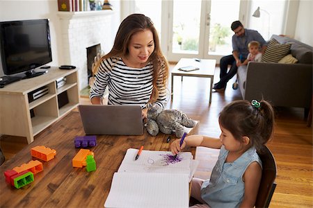 Mother Uses Laptop Whilst Father Plays With Children At Home Stock Photo - Budget Royalty-Free & Subscription, Code: 400-08838331