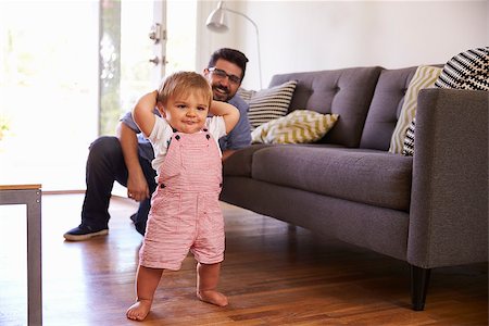 Father Watching Baby Daughter Take First Steps At Home Stock Photo - Budget Royalty-Free & Subscription, Code: 400-08838362