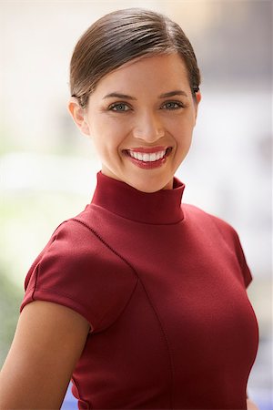 Smiling young white businesswoman in maroon dress, vertical Stock Photo - Budget Royalty-Free & Subscription, Code: 400-08838776