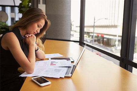 simsearch:400-08838779,k - Businesswoman working reading document in office, side view Stock Photo - Budget Royalty-Free & Subscription, Code: 400-08838816
