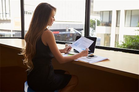 simsearch:400-08838779,k - Businesswoman sitting in modern office reading a document Stock Photo - Budget Royalty-Free & Subscription, Code: 400-08838811
