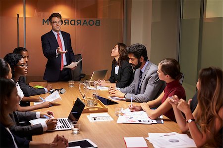 simsearch:400-08838985,k - Businessman stands gesturing to colleagues at a meeting Stock Photo - Budget Royalty-Free & Subscription, Code: 400-08838874