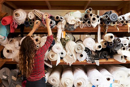 fashion store manager - Young woman reaching to select fabric from storage shelves Stock Photo - Budget Royalty-Free & Subscription, Code: 400-08839058