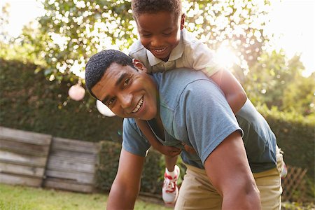 Young black boy playing on dadÕs back in a garden, low angle Stock Photo - Budget Royalty-Free & Subscription, Code: 400-08839215