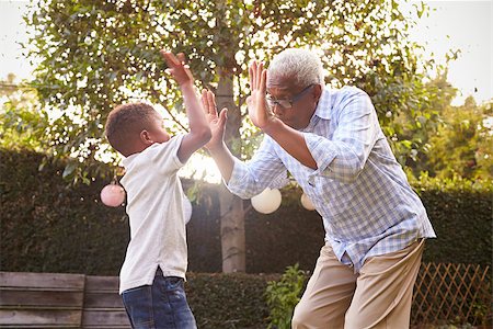 Black grandfather playing with his grandson in a garden Stock Photo - Budget Royalty-Free & Subscription, Code: 400-08839216