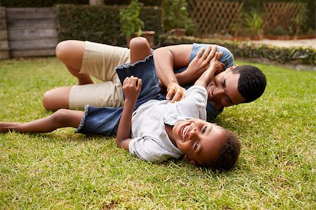 Black father and young son play lying on grass, low angle Stock Photo - Budget Royalty-Free & Subscription, Code: 400-08839223