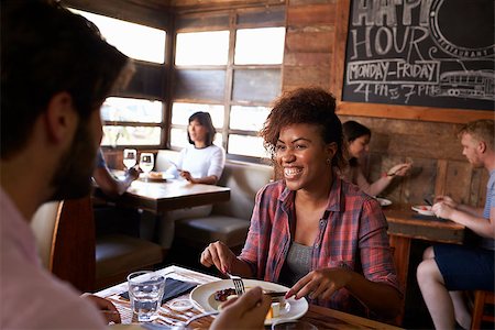 simsearch:400-08292251,k - Mixed race couple having lunch in busy restaurant, close up Stock Photo - Budget Royalty-Free & Subscription, Code: 400-08839279