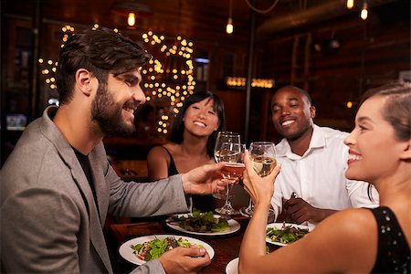 friends table indoor dinner - Four friends making a toast over dinner at a restaurant Stock Photo - Budget Royalty-Free & Subscription, Code: 400-08839331