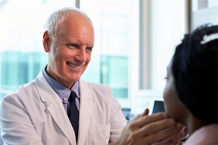 Doctor In White Coat Examining Female Patient In Office Stock Photo - Budget Royalty-Free & Subscription, Code: 400-08839378