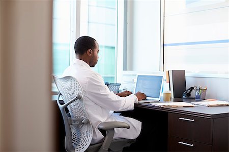 Doctor Wearing White Coat Working On Laptop In Office Stock Photo - Budget Royalty-Free & Subscription, Code: 400-08839440
