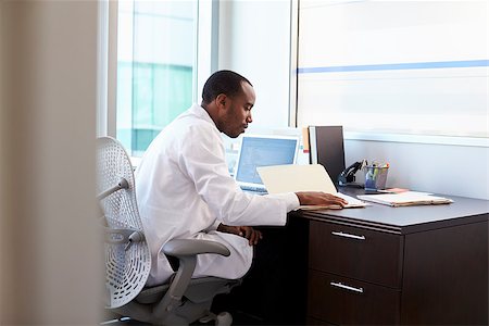 Doctor Wearing White Coat Reading Notes In Office Stock Photo - Budget Royalty-Free & Subscription, Code: 400-08839441