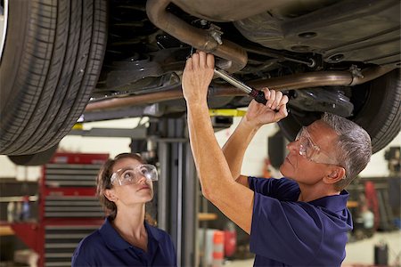 exhaust pipe - Male And Female Mechanics Working Underneath Car Together Stock Photo - Budget Royalty-Free & Subscription, Code: 400-08839571