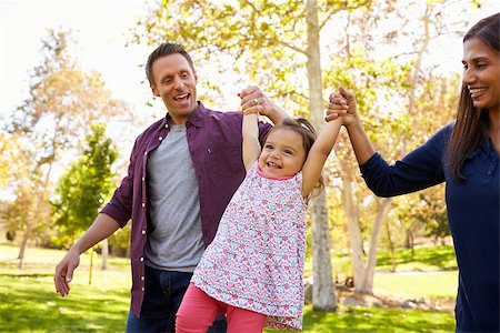 simsearch:400-08839704,k - Mixed race couple lifting young daughter in park, close up Foto de stock - Super Valor sin royalties y Suscripción, Código: 400-08839596