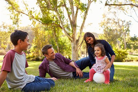 simsearch:400-08839704,k - Young mixed race family relaxing with soccer ball in a park Foto de stock - Super Valor sin royalties y Suscripción, Código: 400-08839663