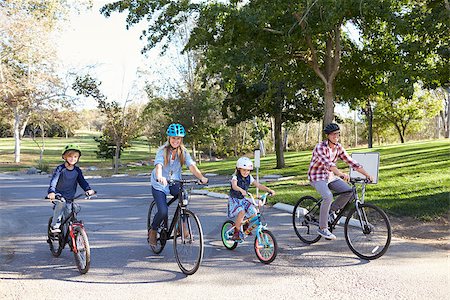 simsearch:400-04499588,k - Young white family cycling together through a park Fotografie stock - Microstock e Abbonamento, Codice: 400-08839676