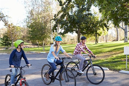 simsearch:400-04499588,k - Parents and young son cycling together through a park Fotografie stock - Microstock e Abbonamento, Codice: 400-08839677