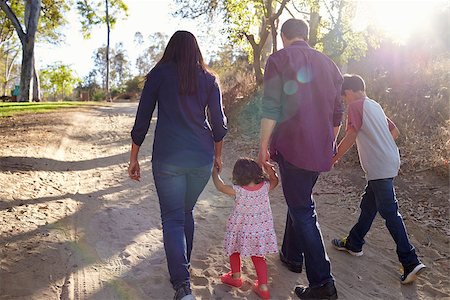 Mixed race family walking on rural path, backlit back view Stock Photo - Budget Royalty-Free & Subscription, Code: 400-08839686