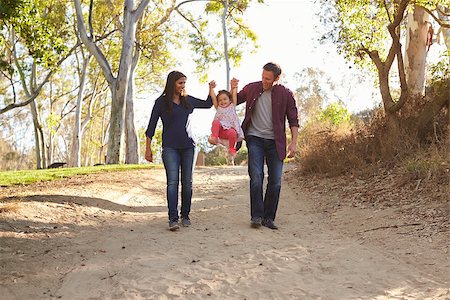 Couple walking on rural path lifting daughter, full length Stock Photo - Budget Royalty-Free & Subscription, Code: 400-08839689