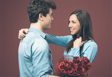 Smiling young woman receiving red roses as love gift from her boyfriend Stock Photo - Budget Royalty-Free & Subscription, Code: 400-08832166