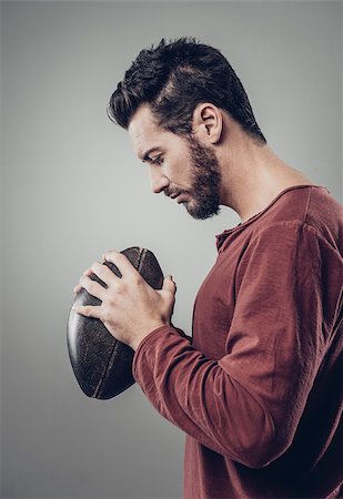 pigskin - Young attractive football player with ball on gray background Photographie de stock - Aubaine LD & Abonnement, Code: 400-08832211