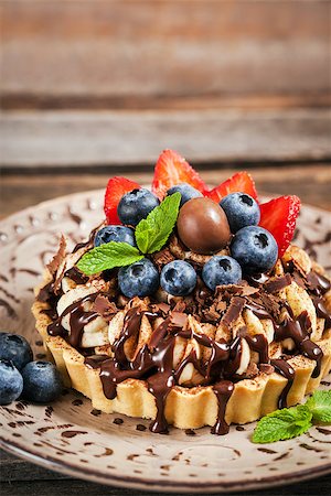 Banoffee  pie (tart) decorated with chocolate, fresh blueberry and strawberry Stock Photo - Budget Royalty-Free & Subscription, Code: 400-08832334