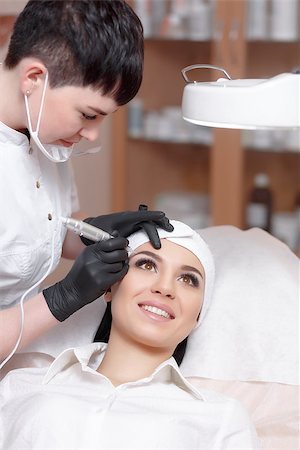 Cosmetologist applying permanent make up on eyebrows- eyebrow tattoo. Permanent make-up tattoo at beauty salon. Permanent makeup. Aesthetic medicine, cosmetology. Cosmetology and makeup salon. Stock Photo - Budget Royalty-Free & Subscription, Code: 400-08832425